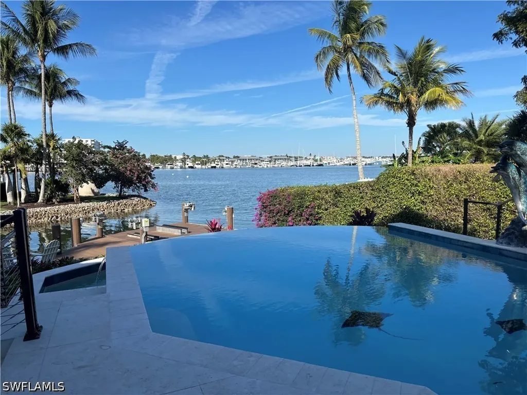 Waterfront infinity pool overlooking Naples Bay; SWFLAMLS watermark retained
